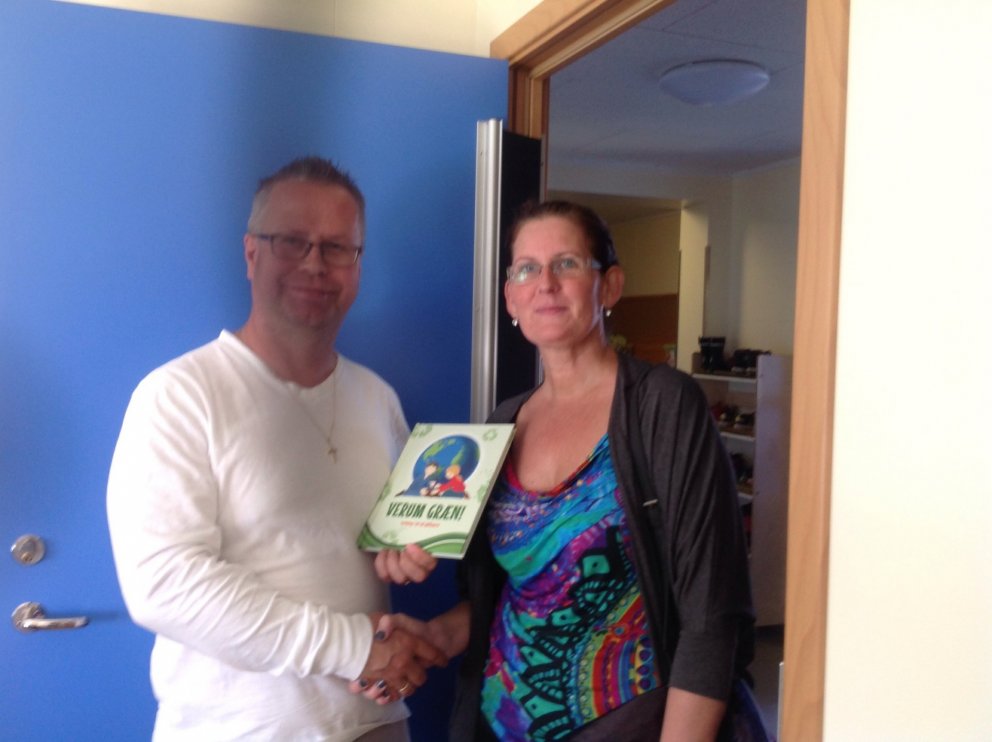 Jón tekur við bókargjöfinni frá Guðrúnu.